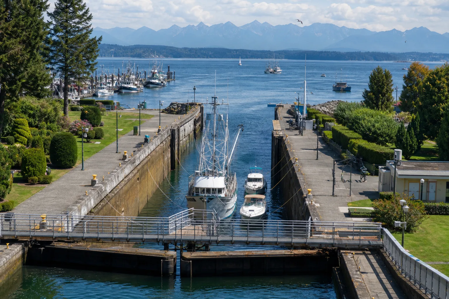 Illustration of a concrete navigation lock with a fishing vessel and pleasure boats inside its chamber, opening west past a moored fishing fleet to a wide saltwater bay with a jagged mountain range on the horizon