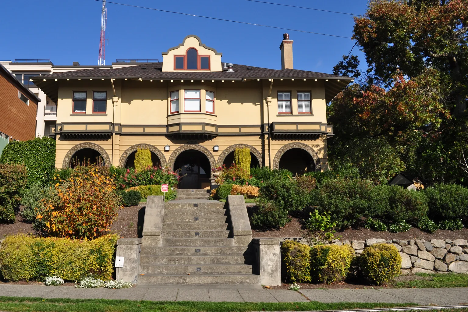 The 1904 Brace/Moriarty House at 170 Prospect Street, a Seattle landmark on the south slope of Queen Anne Hill, its seven-arch masonry veranda set above a terraced rockery and a long flight of steps up from the sidewalk